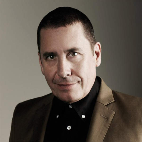 Jools Holland, a white man with short brown hair wearing a brown suit jacket