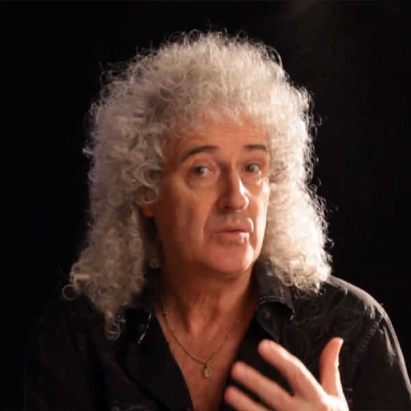 Sir Brian May, an older white man with shoulder length thick curly white hair